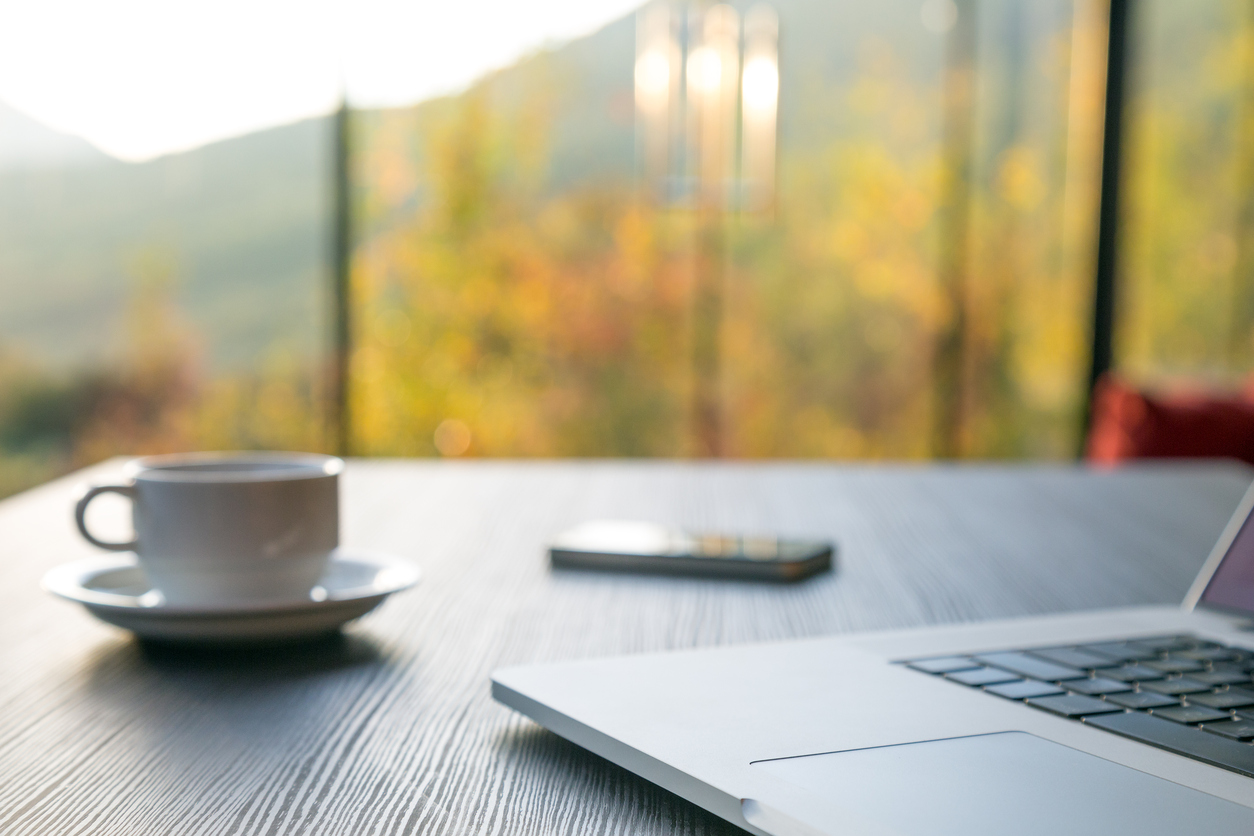 laptop with cup of coffee and phone on a desk