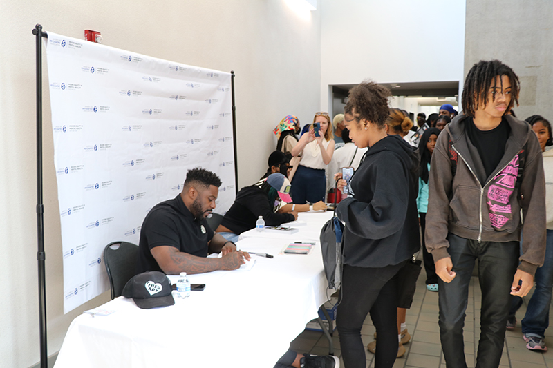 participants at the Youth Summit wait for autographed copies of Jay Barnett's book