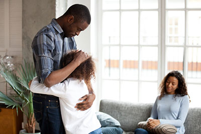 child embracing father while mother looks on